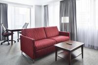ein Wohnzimmer mit einem roten Sofa und einem Tisch in der Unterkunft Club Quarters Hotel Embarcadero, San Francisco in San Francisco