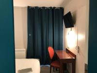 a room with a desk and a bed and a blue curtain at Relais Bergson in Paris