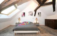a attic bedroom with a bed and two night stands at Demeure de 6 chambres avec piscine interieure jacuzzi et jardin clos a Vernou sur Brenne in Vernou-sur-Brenne