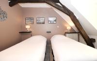 two beds in a attic room with exposed beams at Demeure de 6 chambres avec piscine interieure jacuzzi et jardin clos a Vernou sur Brenne in Vernou-sur-Brenne