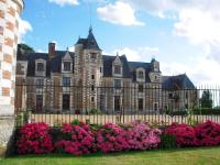 an old building with flowers in front of it at Demeure de 6 chambres avec piscine interieure jacuzzi et jardin clos a Vernou sur Brenne in Vernou-sur-Brenne