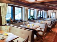 a restaurant with tables and chairs and windows at Alpenhotel Denninglehen in Berchtesgaden