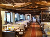 a dining room with tables and chairs and windows at Alpenhotel Denninglehen in Berchtesgaden