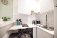 a white kitchen with a stove and a sink at Lovely Home in Paris Center - AC in Paris