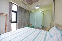 a bedroom with a bed and a large window at Penghu 123 V-Stone in Magong