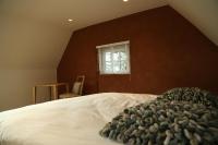 a bedroom with a large white bed with a window at B&amp;B Leonie in Alveringem