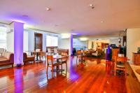 uma sala de estar com pisos e mesas e cadeiras de madeira em Oft Alfre hotels - Goiânia em Goiânia