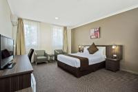 ダンデノンにあるComfort Hotel Dandenongのベッドと薄型テレビがあるホテルの部屋