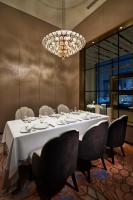 横浜市にあるザ・カハラ・ホテル＆リゾート横浜のテーブルとシャンデリアのあるダイニングルーム