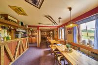 a restaurant with wooden tables and chairs and a bar at Lyžařská bouda in Pec pod Sněžkou