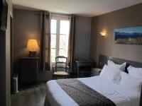 a hotel room with a bed and a window at Logis Hotel Restaurant la Ferme in Avignon