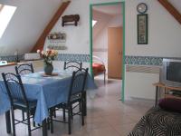 a dining room with a table with chairs and a television at APPARTEMENT WISSANT in Wissant