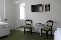 a bedroom with two chairs and a table with a tv at Gästehaus Reckahn der Rochow Akademie in Reckahn