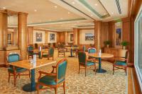 a restaurant with tables and chairs in a room at Crowne Plaza Bahrain by IHG in Manama