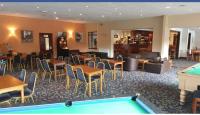 una camera d'albergo con un tavolo da biliardo, tavoli e sedie di SNOWDON LODGE - GLAN GWNA HOLIDAY PARK CAERNARFON - Luxury Family Lodge a Caernarfon