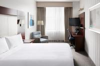 Una habitación de hotel con una cama, una silla y un televisor. en Club Quarters Hotel Wacker at Michigan, Chicago, en Chicago
