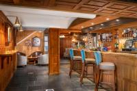 un bar en un restaurante con paredes de madera y sillas azules en Lakeview Manor, en Dunkeswell