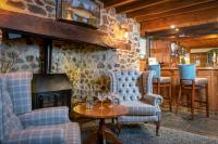 Una sala de estar con dos sillas y una chimenea. en Lakeview Manor, en Dunkeswell