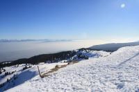 a snow covered hill with a view of the water at Gîte du Bief de la Chaille in Les Rousses