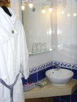 a bathroom with a sink and a white robe at La Ceriseraie in La Gorgue