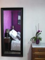 a mirror in a room with a bed and a table at La Ceriseraie in La Gorgue