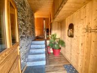 a hallway of a cabin with stairs and a stone wall at Ancienne école du Mont in Servoz