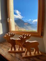 two wooden reindeers sitting on a table in front of a window at Ancienne école du Mont in Servoz