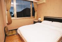 a bedroom with a large white bed and a window at Levite Villa in Jiufen
