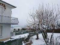 a tree covered in snow next to a house at Appartement T2 in Lau-Balagnas