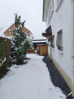 a snow covered alley next to a white building at appartement Isabelle in Lau-Balagnas