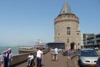 a group of people walking on a sidewalk next to a tower at Rijksmonument Havenzicht, met zeezicht, ligging direct aan zee en centrum in Vlissingen