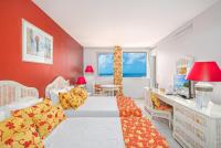 a bedroom with two beds and a red wall at Karibea Squash Hôtel in Fort-de-France