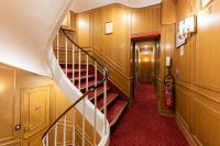 a staircase in a house with wooden walls and red carpet at Hôtel La Sanguine in Paris