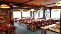 un ristorante con tavoli e sedie in legno e luci di Rimrock Lodge LLC a Thompson Falls
