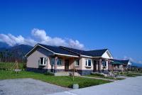 a house with a black roof on a street at Countryside B&amp;B in Ruisui