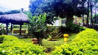 a garden with a yellow fire hydrant and bushes at Pousada Mama África in Conservatória