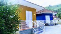 a blue and yellow house with a white door at Pousada Mama África in Conservatória
