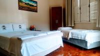 two beds sitting next to each other in a room at Pousada Mama África in Conservatória