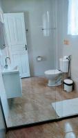 a bathroom with a toilet and a glass door at Pousada Mama África in Conservatória