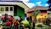 a green and orange house with plants in front of it at Pousada Mama África in Conservatória
