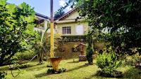 a house in a garden with a yard with trees at Pousada Mama África in Conservatória