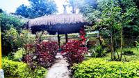 a thatch roof hut with a bunch of flowers at Pousada Mama África in Conservatória