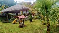 a palm tree and a hut with a palm tree at Pousada Mama África in Conservatória