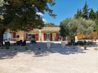 a house with trees and chairs in front of it at Mas du Tilleul in Beaumes-de-Venise