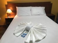 a white bed with a bow tie on it at Pousada Bougainville in Três Corações