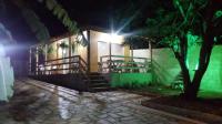 a building with stairs and a tree at night at Pousada Bougainville in Três Corações