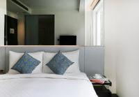a bed with blue and white pillows and a mirror at CityInn Hotel Plus - Taichung Station Branch in Taichung