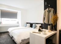 a bedroom with a bed and a desk with a laptop at CityInn Hotel Plus - Taichung Station Branch in Taichung
