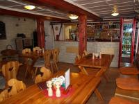 a restaurant with wooden tables and chairs and a bar at Chata Mísečky in Horni Misecky
