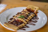 un plato blanco con comida en una mesa de madera en Casa Chapolin Boutique Guesthouse, en Palomino